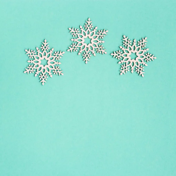 Weihnachtsgrußkarte Mit Hölzernen Schneeflocken Auf Minzpapier Hintergrund Mit Kopierraum Neujahrsdekoration — Stockfoto