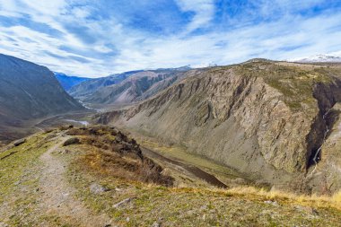 Altai Cumhuriyeti 'ndeki Chulyshman Vadisi' nin güzel manzarası. Uzağa uzanan dağlar, şelale ve bulutlar mavi gökyüzüne. Rusya 'nın vahşi doğası.