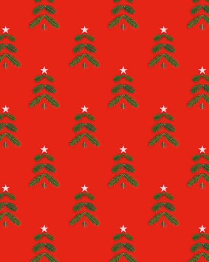 Çam dallarından gelen yeşil Noel ağacı ve kırmızı zemin üzerinde yılbaşı ağacı olan yaratıcı bir Noel deseni. Minimum kış tatili