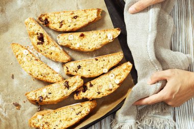 İtalyan bisküvileri siyah yemek tepsisi üzerinde. Fındıklı ve kuru yaban mersinli taze kurabiyeler..