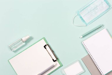 Ofis malzemeleri ve kişisel koruyucu ekipmanlar. Defterler, kalemler, tek kullanımlık tıbbi yüz maskesi ve el dezenfektanı..