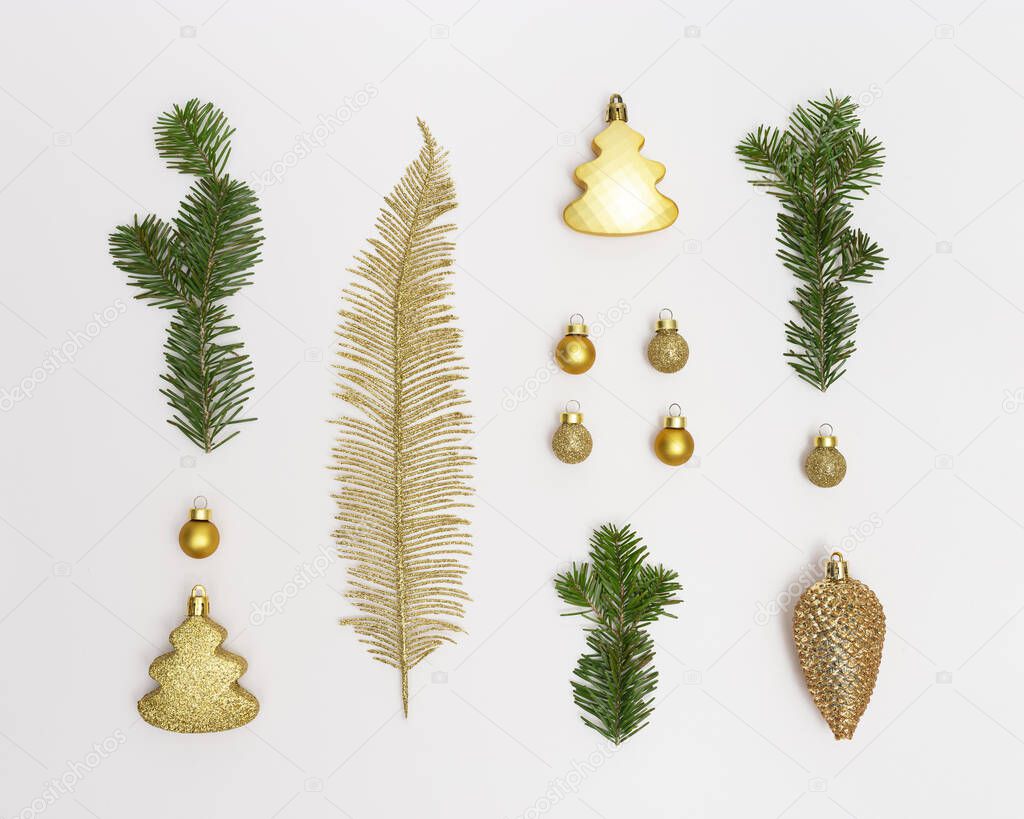 Christmas composition with golden christmas decor, green fir branches, balls,  palm leaf, shine pine cone, glitter fir tree on white background. New Year holiday decoration. Flat lay, top view.