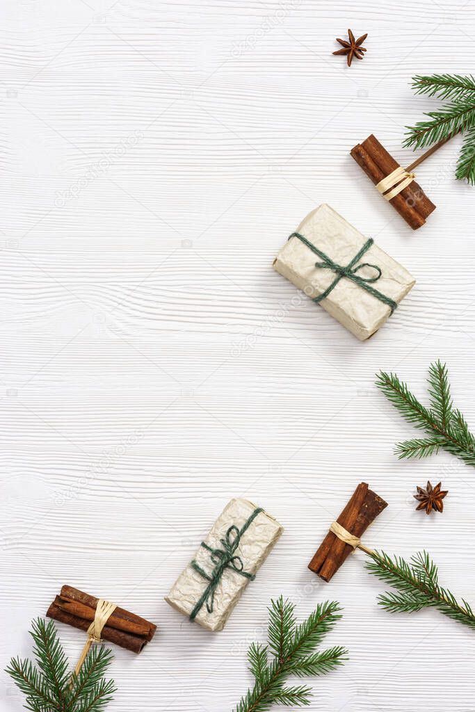 Handmade Christmas gifts decorated fir branches and cinnamon, winter holidays and New Year background with copy space. Flat lay. Top view.