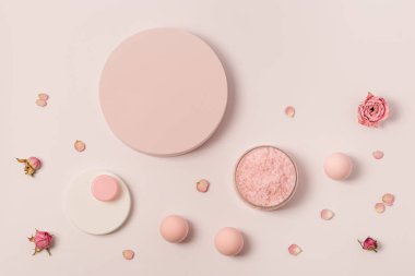 Aromatik deniz tuzu kristalleri ve kopyalanmış uzayı olan gül yağı çiçeği. Kozmetik banyo ürünü üst görünümü olan spa kompozisyonu, pembe pastel renkli, asgari eğilim.