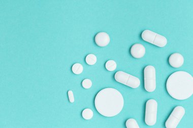 Çeşitli ilaç hapları, haplar ve kapsüller mavi arka planda. Sağlık hizmetleri. Tıbbi geçmişi var. Üst Manzara. Boşluğu kopyala