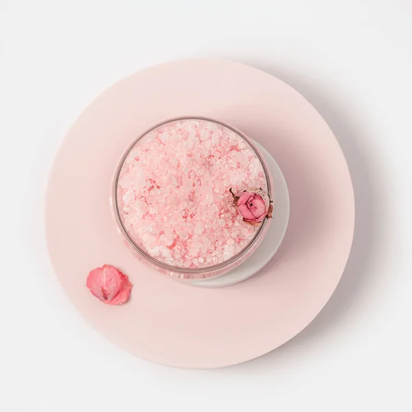 キャップとラウンド表彰台にバラの花と瓶の中のバラの香りの美しさの海塩 化粧品トップビュー ピンクのパステルカラー 最小限の傾向 — ストック写真