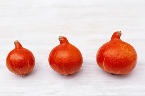 Três Pequenas Abóboras Sucessivamente Mesa Madeira Branca Decoração Outono Legumes — Fotografia de Stock