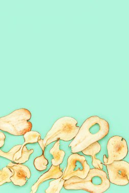 Sağlıklı atıştırmalıklar. Ev yapımı kurutulmuş armut cipsi. Kağıt üzerinde kuru armut. Diyet gıda konsepti. Üst görünüm ve kopyalama alanı.