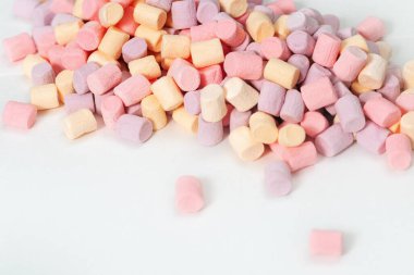 Pek çok renkli Zephyr 'in geçmişi. Beyazın üzerine çok renkli küçük şekerleme. Fotokopi alanı olan tatlı yemek fonu. Seçici odak.