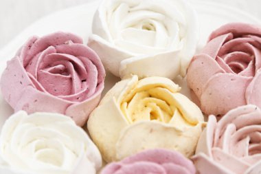 Beyaz bir tabakta çok renkli narin bir zephyr. Güzel ve lezzetli düşük kalorili tatlı. Yaratıcı Berry Zefir. Yaklaş, seçici odaklanma.