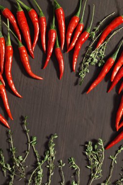 Koyu beton arka planda kırmızı biber ve limonlu kekik. Üst görünüm ve düz uzanma.