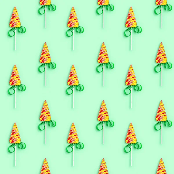 お正月やクリスマスのための色キャンディ創造的なシームレスなパターン 緑の背景にクリスマスツリーのような形をしたロリポップ 幸せな休日とお祝いのお菓子 — ストック写真