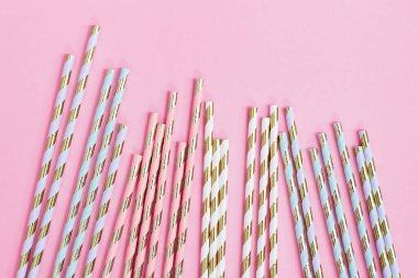 Çizgili desenli renkli kağıt kokteyl pipetleri. Doğum günü ya da tatil için altın rengi. Yaratıcı geçmişi kutluyoruz. Üst görünüm.