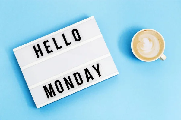 Text hello monday on lightbox and cup of coffee for holiday - Thank God Its Monday. Start of working week concept. Top view on blue background.