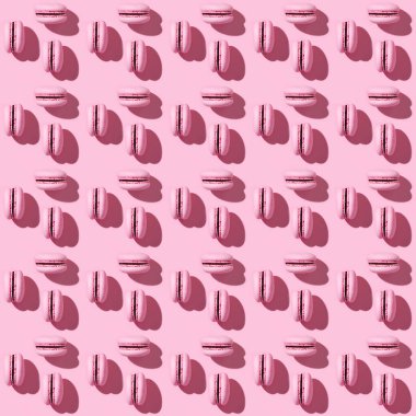 Seamless regular creative pattern of bright pink french cookies macarons. Printing on fabric, wrapping paper. Monochrome image.