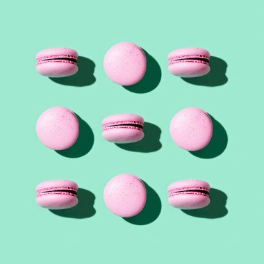 Regular creative pattern of colorful french cookies macarons. Greeting card for party or holiday.