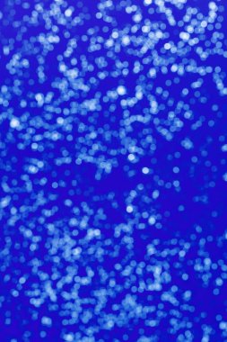 Bright bokeh on blue. Defocused abstract background. White Boke texrure.