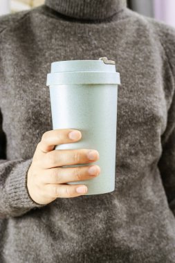 Yeniden kullanılabilir çevre dostu bambu fincanı kadınların eline yakın kahveleri götürmek için. Düşük etkili sürdürülebilir yaşam tarzı için çevre dostu sıfır atık çözümü.