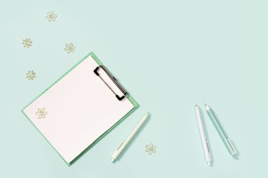 Flat lay with mock-up notebook and stationery for school or office. Blue and white colored pens, ruler and metal paperclips. School equipment. Top view with copy space.