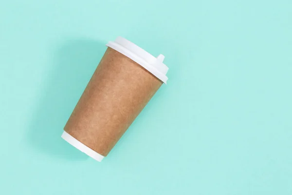 Blank craft take away big paper cup for coffee or drinks, packaging template mock up on mint colored background with copy space.