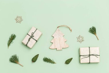 Noel veya Yeni Yıl kompozisyonu. Noel hediyesi kutuları, çam kozalakları, ladin dalları, açık mavi arka planda fotokopi alanı olan ahşap oyuncaklar. Üst görünüm.