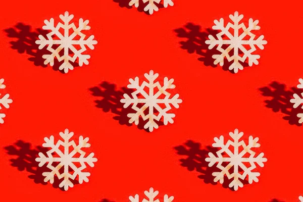 有木制雪花和红色背景的黑暗阴影的圣诞图案 用天然材料木作过冬装饰 新年假期的概念 — 图库照片