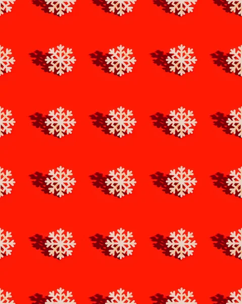 Kırmızı arka planda doğal malzemeden yapılmış kar tanecikli oyuncaklarla Noel düzeni. Yılbaşı süsleri, güneş ışığından gelen gölgelerle.