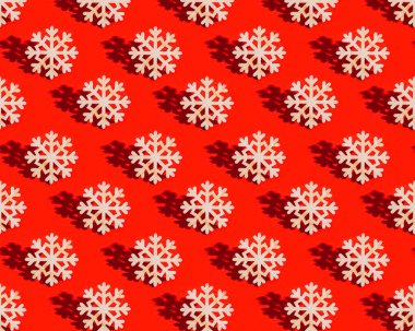 Noel desenli, ahşap kar taneli ve kırmızı arka planda koyu gölgeli. Doğal malzeme odunundan kış kutlaması için dekorasyon. Yeni yıl tatili konsepti.