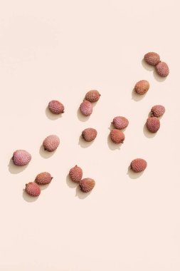 Pastel bej arka planda taze Lychee meyvesi deseni. Minimum meyve ve yaz konsepti. Üst görünüm ve gün ışığı.