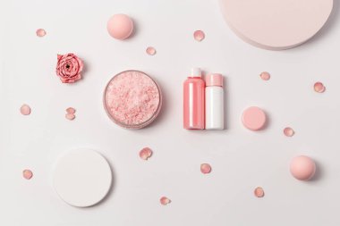 Aromatik deniz tuzu kristalleri ve gül yağı çiçeği. Kozmetik banyo ürünü üst görünümü olan spa kompozisyonu, pembe pastel renkli, asgari eğilim.