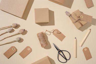 El yapımı el yapımı hediye kutuları. Etiketleri açık bej arka planda doğal kuru haşhaş çiçekleri. Çevre dostu tatil konsepti. Kopyalama alanı olan düz.