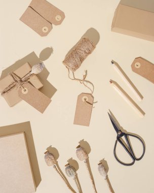 El yapımı el yapımı hediye kutuları. Etiketleri açık bej arka planda doğal kuru haşhaş çiçekleri. Çevre dostu tatil konsepti. Kopyalama alanı olan düz.