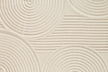 Japon Zen Bahçesi 'nde meditasyon ve sükunet için kumun üzerinde eşmerkezli daireler. Estetik minimumda kumlu arka plan. Üst görünüm.