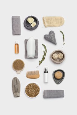 Spa natürmort bir yaşam. Beyaz yüzeyde vücut bakımına hazır olun. Jöleli ya da şampuanlı şişeler, sabun, ahşap tarak, banyo için bez, deniz tuzu.