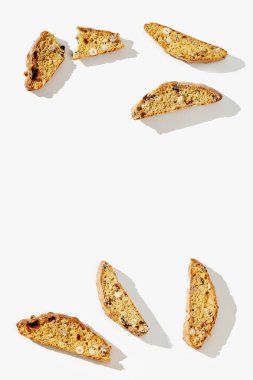 Beyaz arka planda birkaç parça İtalyan bisküvisi. Fındıklı ve kuru kızılcıklı taze kırılmış kurabiyeler. Üst görünüm.