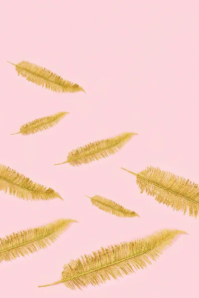 Golden palm leaf design elements on millennial pink paper with copy space. Minimal greeting card.