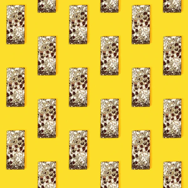 ナッツと黄色の背景にドライフルーツとかまれたチョコレートバーとシームレスな定期的な創造的なパターン 布に印刷 包装紙 — ストック写真
