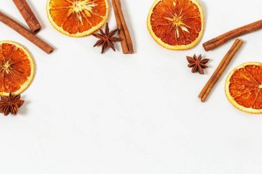 Tarçın çubukları, anason yıldızları, açık betonda kurutulmuş portakallar. Baharatların çerçevesi sıcak şarap için. Düz konum, üst görünüm, kopyalama alanı.