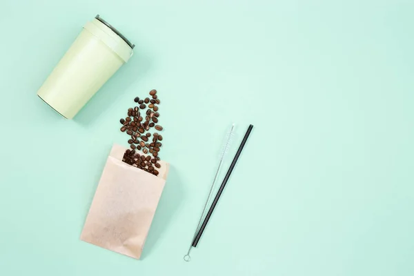 Reusable eco coffee cup, roasted coffee beans and metal drinking straw. Zero waste concept, flat lay. Take away big mug for drinks.