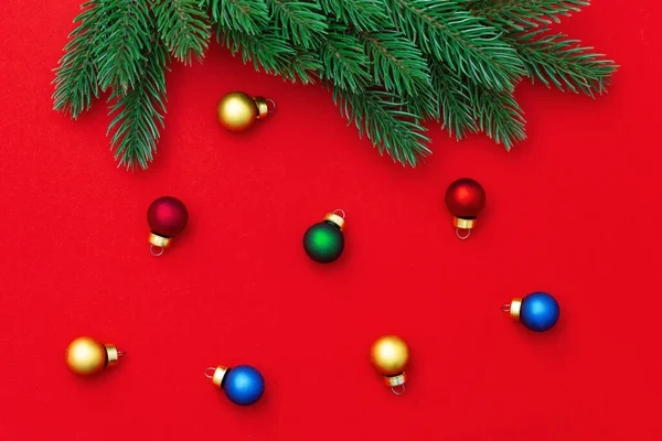 クリスマスツリーの枝と赤い紙の背景に多くの小さなガラスボールを持つクリスマスの背景 新年の装飾 — ストック写真