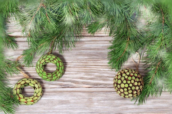 クリスマスツリーの枝に手を渡す木製のおもちゃは 光とボケと光の背景に小さな新年のガラスボールを装飾しました トーン画像 — ストック写真