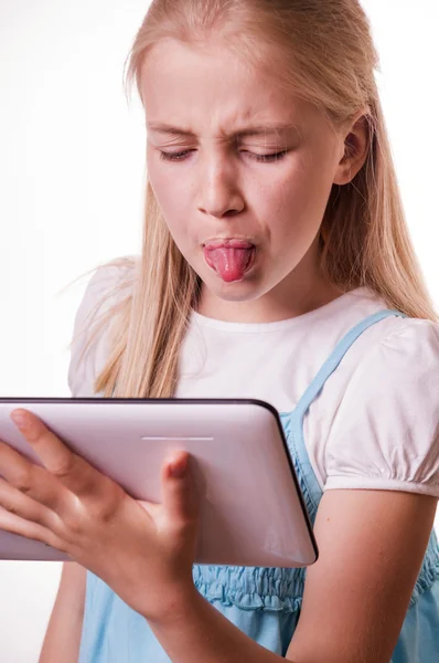 Muchacha mostrando lengua en el comprimido — Foto de Stock