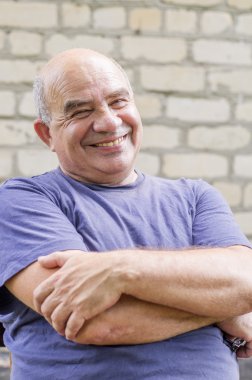 Yaşlı adam kollarını çapraz gülüyor
