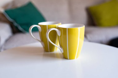 Beyaz bir masanın üstünde yeşil kupalar.