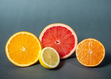 Turunçgiller, greyfurtlar, limonlar, portakallar, gri arka planda..