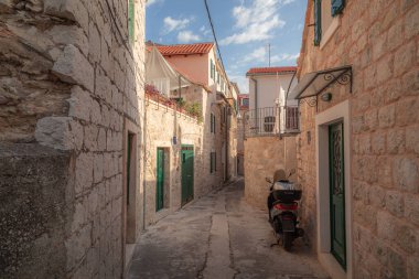 Sıcak, güneşli bir öğleden sonra Hırvatistan 'ın Split kentindeki bu tuhaf mahallede yalnız bir scooter park halinde..