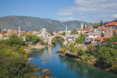 Bosna-Hersek 'in eski Mostar kenti Neretva Nehri üzerindeki Stari Most' un güneşli bir yaz gününde klasik manzarası.