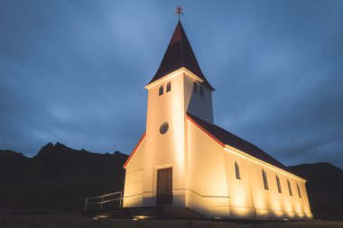 Akşam, İzlanda 'nın güneyindeki Vik kıyı köyünde, aydınlık bir Reyniskyrka Kilisesi' nin manzarası..