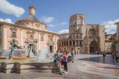Turistler İspanya 'nın başkenti Valencia' nın tarihi meydanı Plaza de la Virgen 'de bir haritaya bakıp güneşli bir günün tadını çıkarıyorlar.
