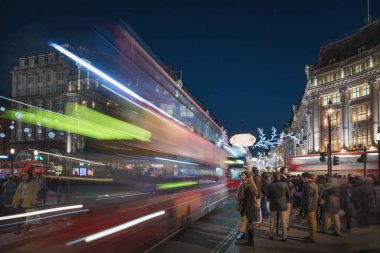 Regent St. ve Oxford Caddesi 'ndeki Noel alışverişçileri çift katlı bir otobüs geçerken...